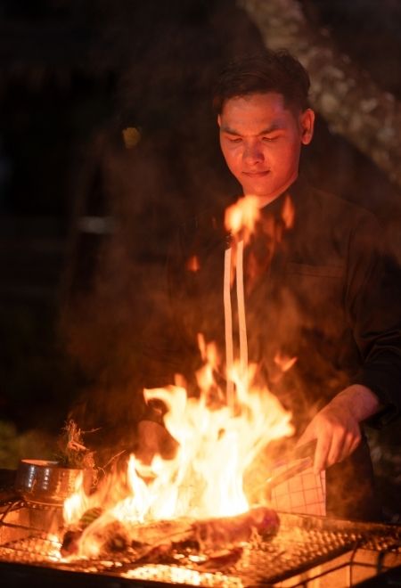 Chef grilling over an open flame at FLARE Flame & Flavour in Phuket