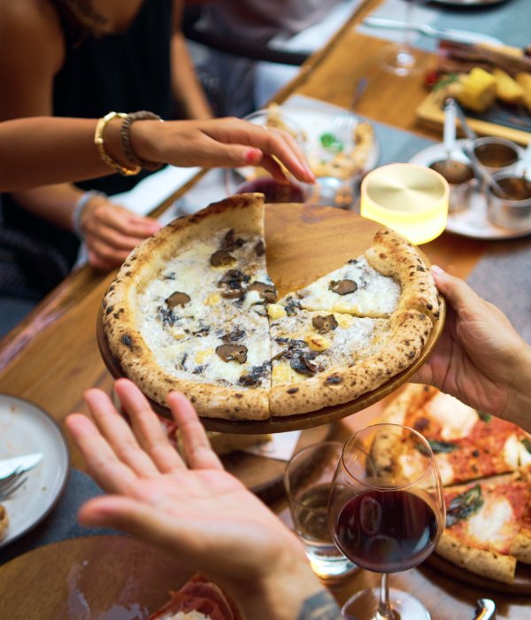 Customer sharing mushroom pizza with each other