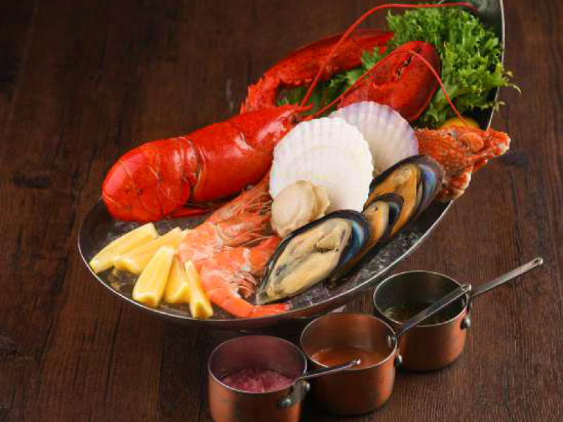 Seafood served on ice with lemon and three sauce provided