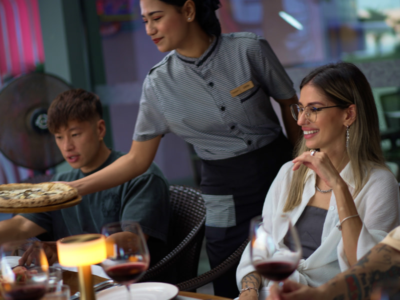 Waitress serving pizza to the customers