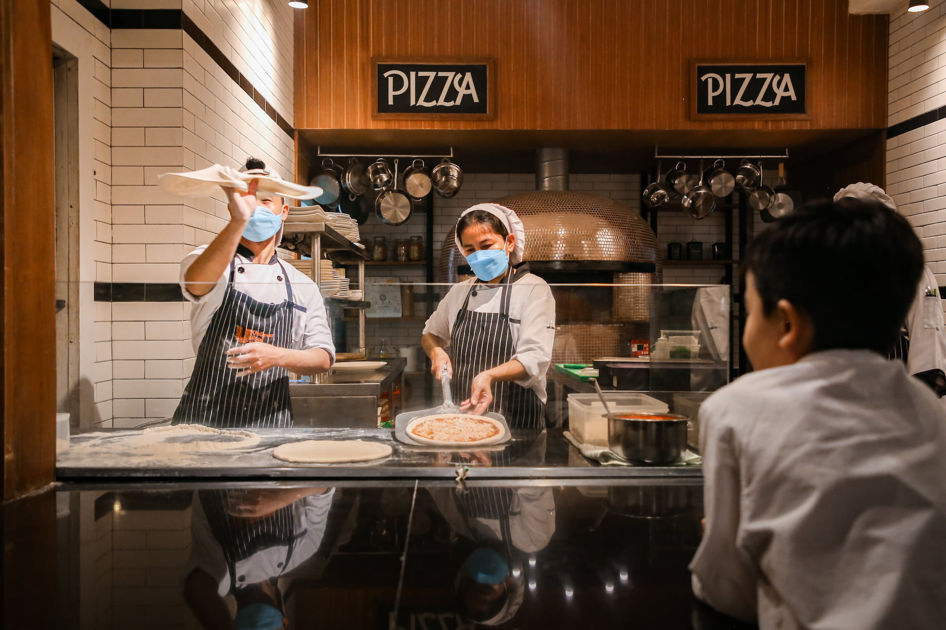 Chefs Flipping Pizza Dough At Ciao Pizza And Grill