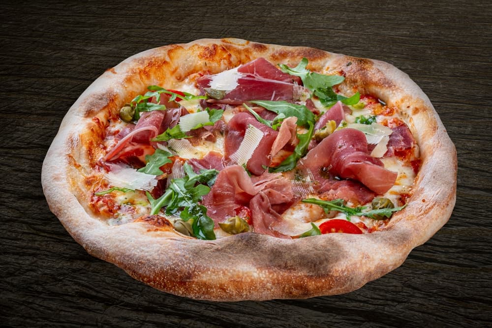 Pizza With Prosciutto And Arugula And Parmesan