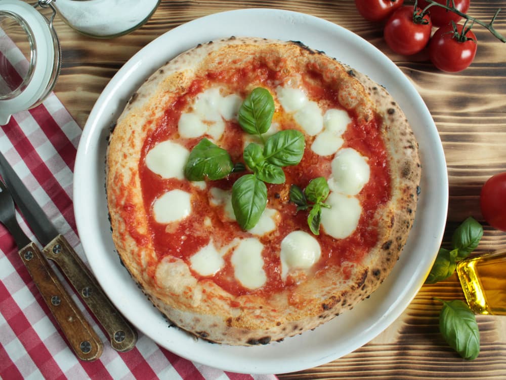 a traditional Napoli style pizza margherita with lumps of buffalo mozzarella cheese